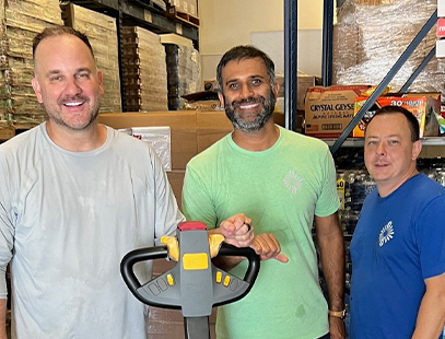 three kainos employees volunteering at a food pantry