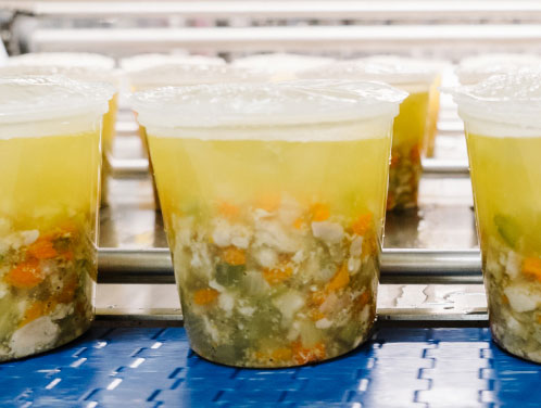 Rows of packaged soup on a production line