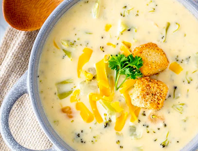 Close up of broccoli cheese soup in gray dish